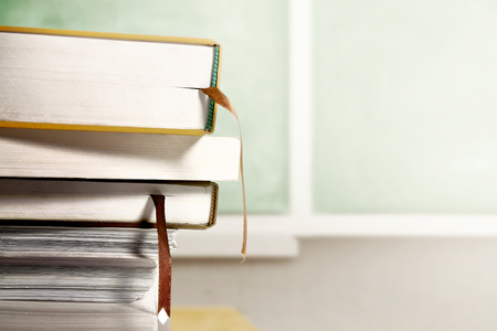 Close up view of pile of books on wooden table with chalkboard background. Back to School conceptの写真素材