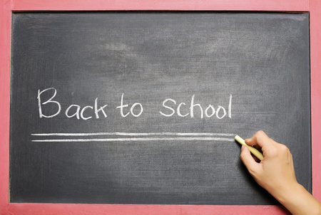 Student hands writing Back to School on the blackboard. Back to School conceptの写真素材