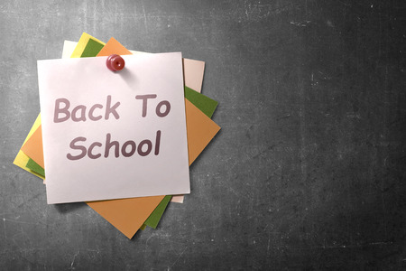 Colorful note paper in push pin with Back to School text on blackboard background. Back to School conceptの写真素材
