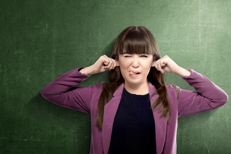Asian student woman with funny expression standing with chalkboard background. Back to School conceptの写真素材