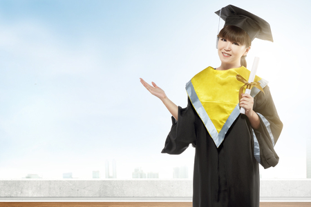 Asian woman in mortarboard hat and diploma graduating from college. Graduation conceptの写真素材