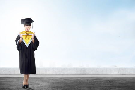 Asian woman in mortarboard hat and diploma graduating from college. Graduation conceptの写真素材