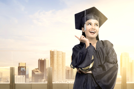Asian woman in mortarboard hat graduating from college. Graduation conceptの写真素材