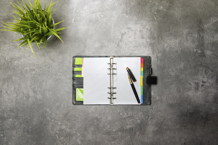 Top view of business desk with potted plant and notebook on the officeの写真素材