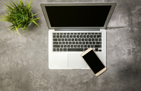 Top view of business desk with potted plant, laptop and mobile phone on the officeの写真素材