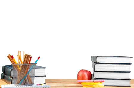 Pile of books with notes paper and pen, apple and pencils in basket container on wooden table isolated over white background. Back to School conceptの写真素材