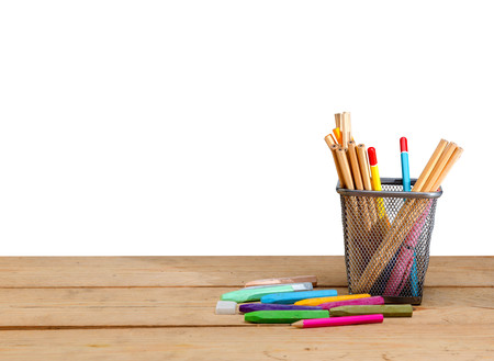 Pencils in basket container and colorful crayons on wooden table isolated over white background. Back to School conceptの写真素材