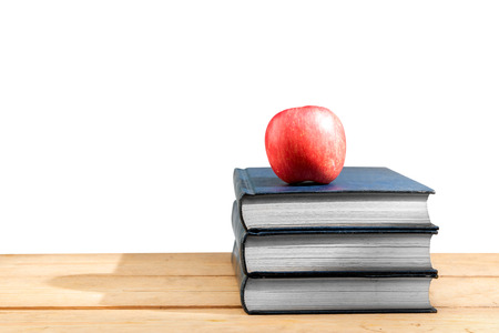 Pile of books with apple on wooden table isolated over white background. Back to School conceptの写真素材