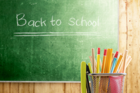 Pencils in basket container with green stapler with chalkboard background. Back to School conceptの写真素材