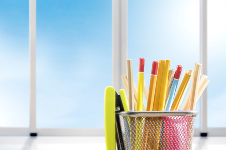 Pencils in basket container with green stapler with window glass background. Back to School conceptの写真素材