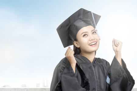 Asian woman in mortarboard hat graduating from college. Graduation conceptの写真素材