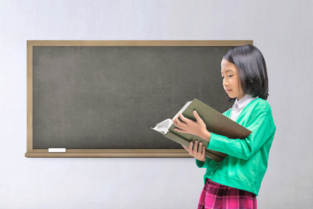 Young asian kid reading book with class backgroundの写真素材