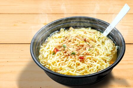Noodles on the bowl with fork on wooden table backgroundの写真素材