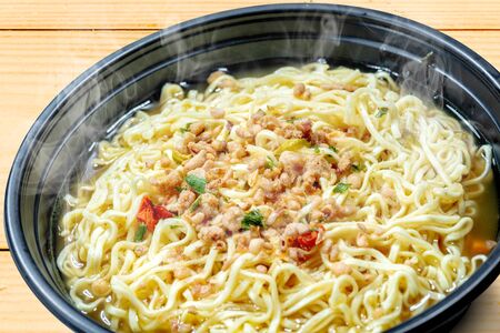 Close up of noodles on the bowl on wooden table backgroundの写真素材