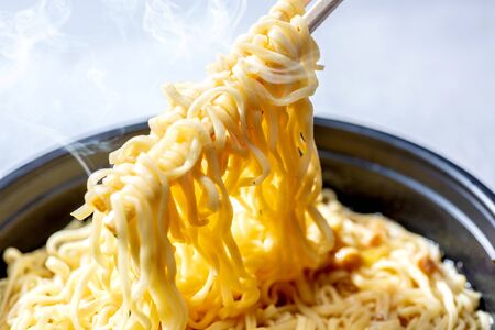 Close up of eat the noodles with chopsticks over bright backgroundの写真素材