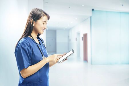 Asian woman nurse with stethoscope using tablet on the hospitalの写真素材