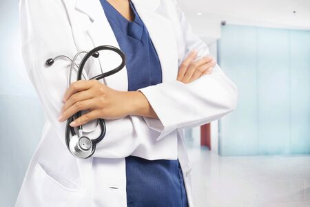 Woman doctor in white lab coat holding stethoscope on her hands on the hospitalの写真素材