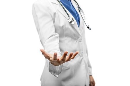 Woman doctor in a white lab coat and stethoscope with open palm isolated over white backgroundの写真素材