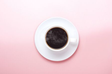 The cup with hot coffee over a pink backgroundの写真素材