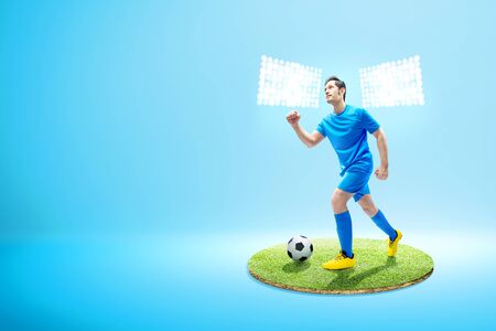 Asian football player man running with the ball on the football field with spotlightsの写真素材