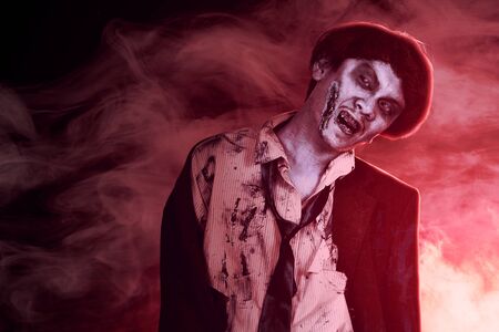 Scary zombies with blood and wound on his body walking amid the dark fog. Halloween concept