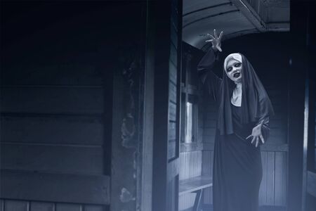 Frightening devil nun on the old wagon. Halloween conceptの写真素材