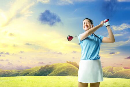 Asian woman swing the wood golf club on the green golf courseの写真素材