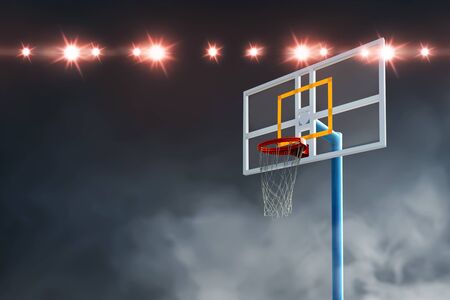 Close up view of the basketball hoop with spotlights over dark backgroundの写真素材