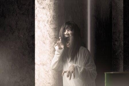 Scary ghost woman with blood and angry face with clawing hands haunted the abandoned building....