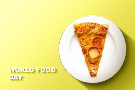Slice of pizza on the plate with World Food Day text on a colored background. World Food Dayの写真素材