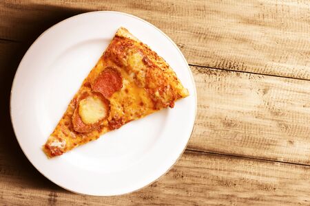 Slice of pizza on the plate on a wooden table background. World Food Dayの写真素材