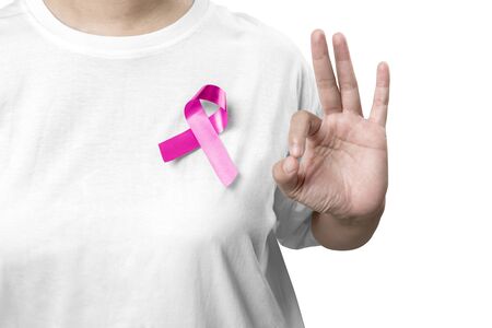 Woman in a white shirt with pink ribbon and showing OK sign isolated over white background. Breast cancer awarenessの写真素材