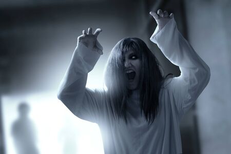 Scary ghost woman with blood and angry face with clawing hands haunted the abandoned building. Halloween conceptの写真素材