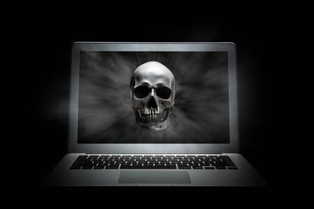 Human skull on laptop screen over black background