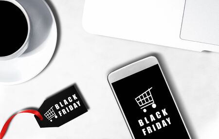 Mobile phone screen with Black Friday advert and label with Black Friday text on the desk. Black Friday conceptの写真素材