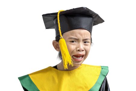 Asian little girl in hat and graduation gown holding certificate crying isolated over white backgroundの写真素材