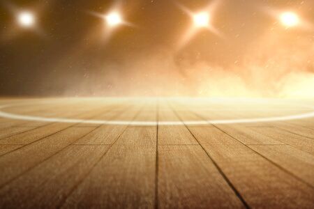 Close up view of a basketball court with wooden floor and spotlights over dark backgroundの写真素材