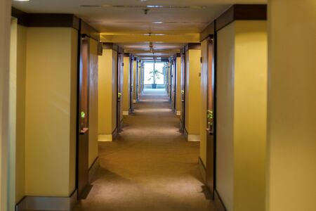 Hotel hallway with bright light and window glass at the end