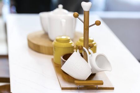 Jars and teapot with wooden rack holder stand for hanging mugs in the kitchenの写真素材