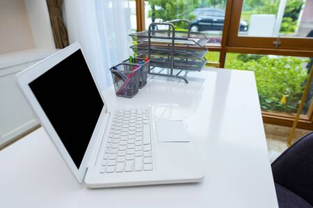 Laptop with office supplies on the desk in the workplaceの写真素材
