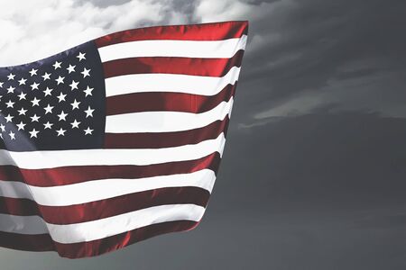 American flag waving in the air with a dramatic background. Fourth of July Concept