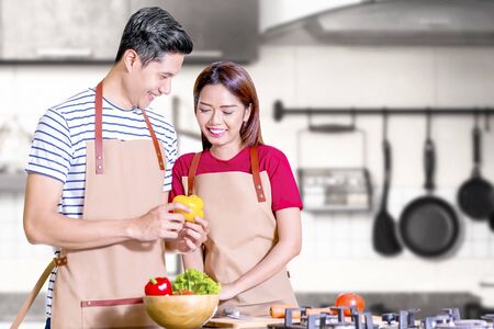 Asian couple cooking food with kitchenware on the kitchen roomの写真素材