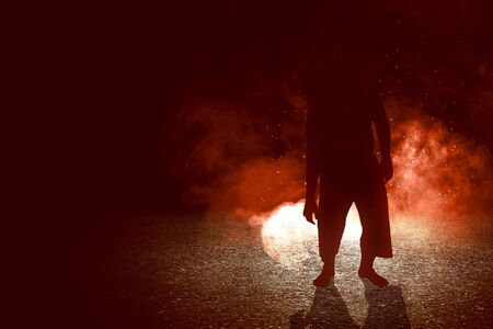 Silhouette of zombie walking with an explosion on black background