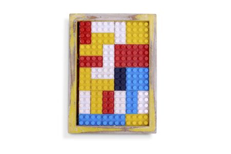 Colored bricks toy in a wooden frame isolated over white background