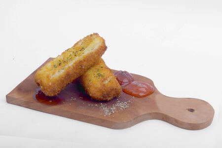 Croquette with tomato sauce and chili sauce on wooden board isolated over white background