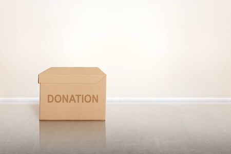 Donation box for collecting donations on the floor with white wall background