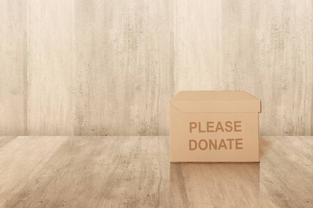 Donation box for collecting donations on the floor with wooden wall background 