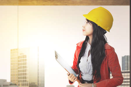 Asian construction worker with hardhat holding clipboard with plan work. Happy Labor Day