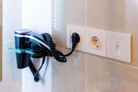 Close up view of hairdryer hanging in the wall