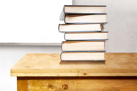 Desk with a stack of books with a whiteboard background. Back to School conceptの写真素材